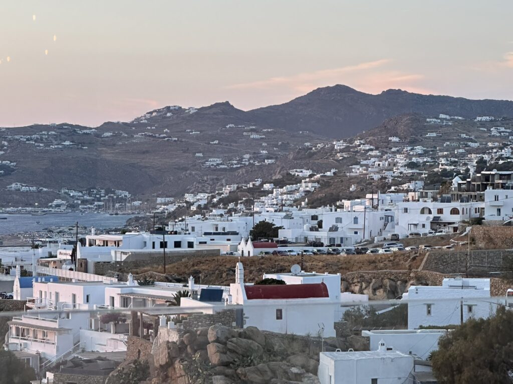 Aerial view of Mykonos Town (Chora) showing the whitewashed Cycladic architecture stacked above the Aegean Sea